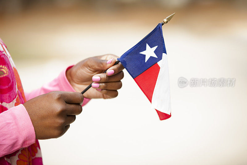 非洲裔妇女举着美国德克萨斯州的国旗。