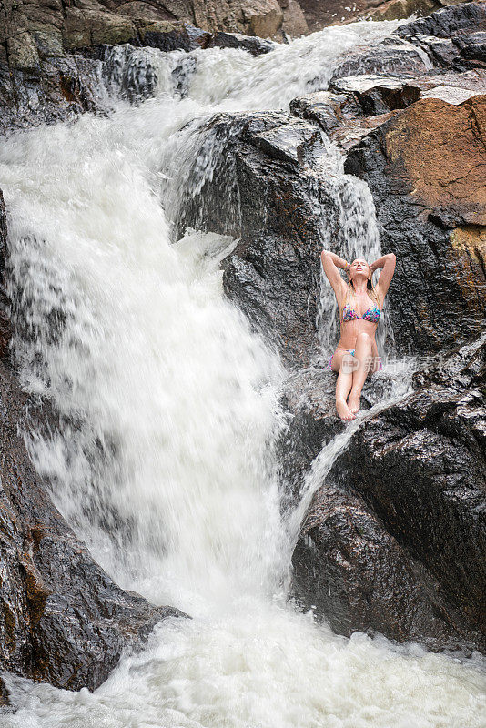 金发美女在一个天然瀑布温泉，泰国