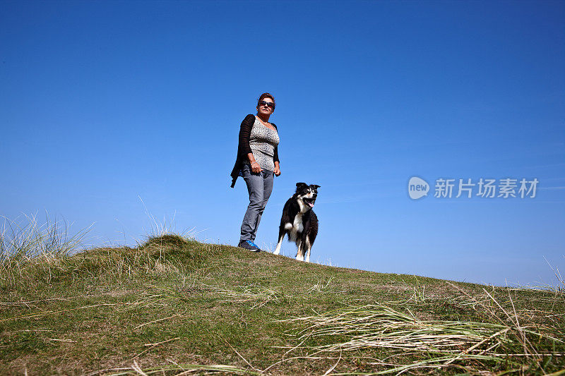 成熟的西班牙女人站在草海岬上