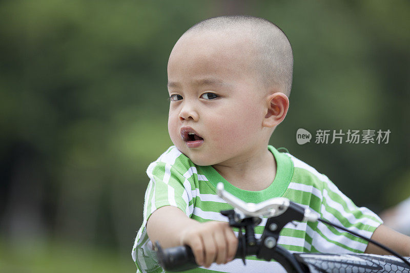 愤怒的小男孩坐在自行车上