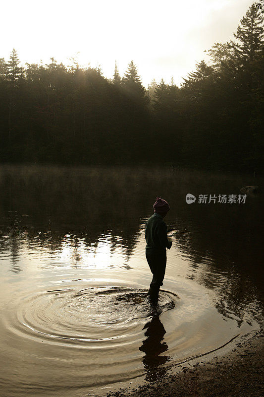 黎明时分在湖中漫步的女孩