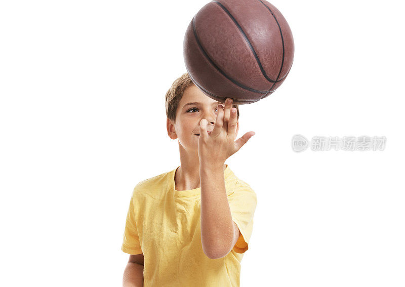 小男孩在玩一个篮球孤立在白色
