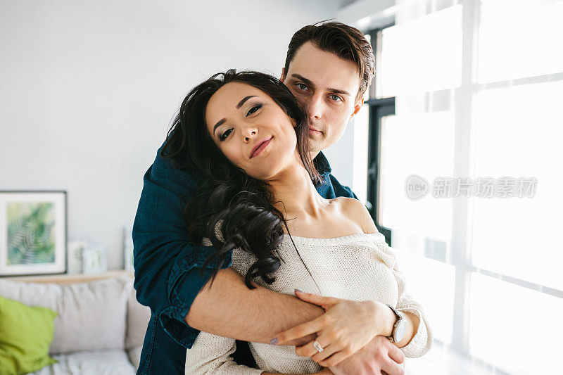 年轻漂亮的女人拥抱着一个男人。关心、可靠、爱和人与人之间的亲密关系。