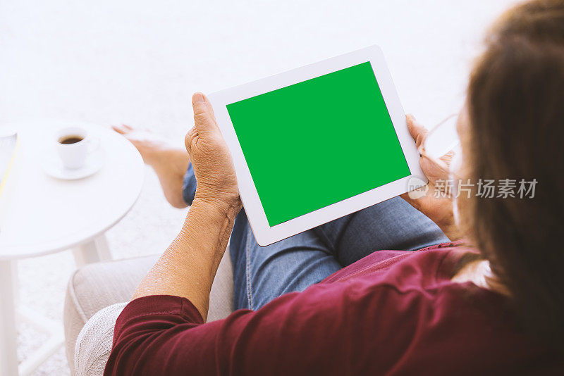 高级女性使用绿色屏幕的数字平板电脑