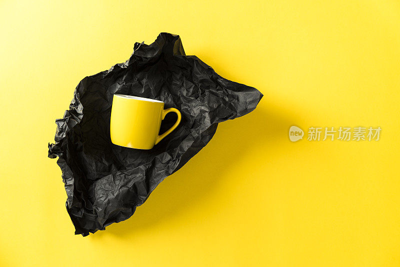 黄色陶瓷马克杯，黑色包装纸，黄色背景