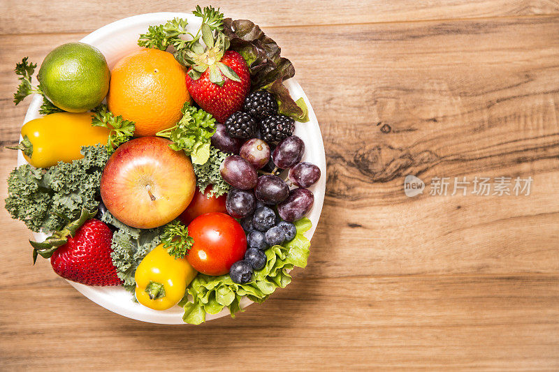 健康的水果和蔬菜在碗木背景