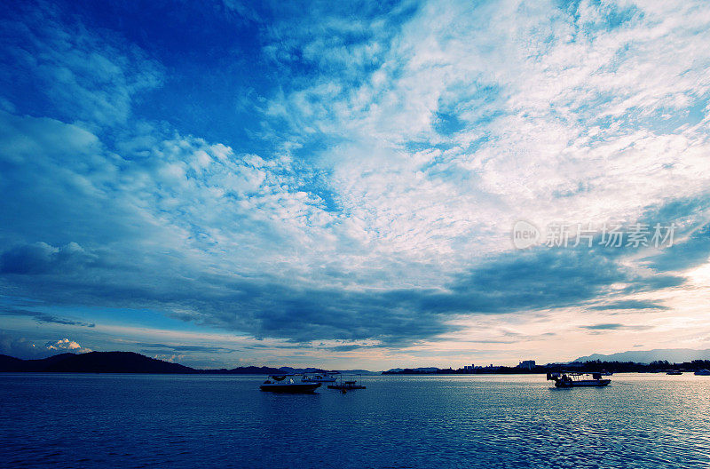 宁静的海滩和船在日出在沙巴州，马来西亚