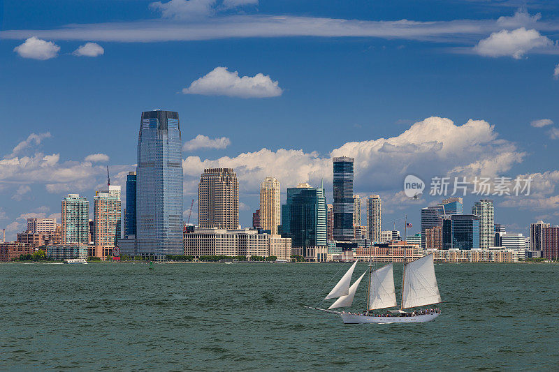 泽西城天际线与高盛大厦，水的纽约港，帆船(高船)和蓝天。