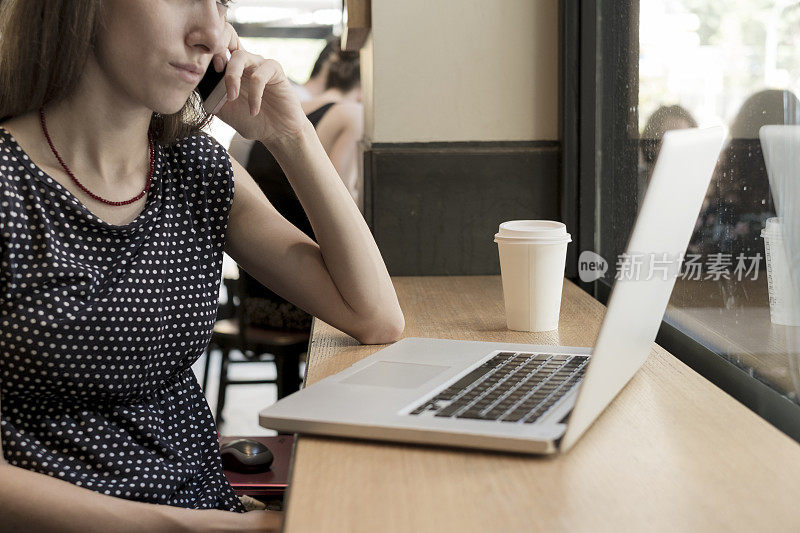 一个在咖啡馆用笔记本电脑工作的女人