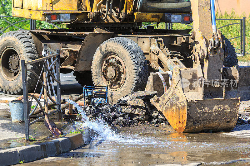 挖掘机有助于消除炎热的夏天在街上弄断水管的问题