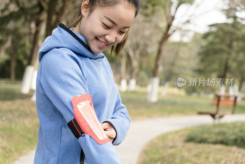 年轻活跃的女子在慢跑前戴臂章