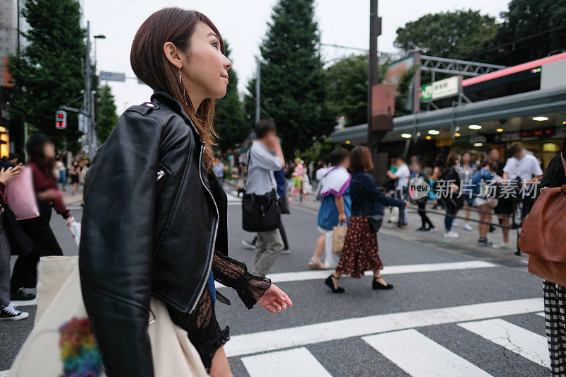 一名女子走在原宿车站前的人行横道上