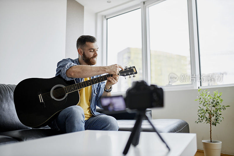 吉他手录制自己的视频，同时在卧室工作室弹奏电吉他