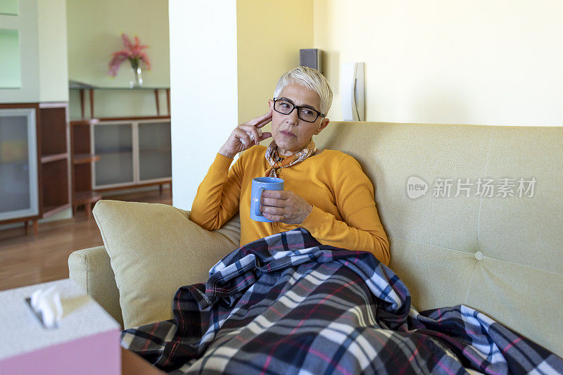 生病的老妇人在床上与季节性过敏喝一杯茶。