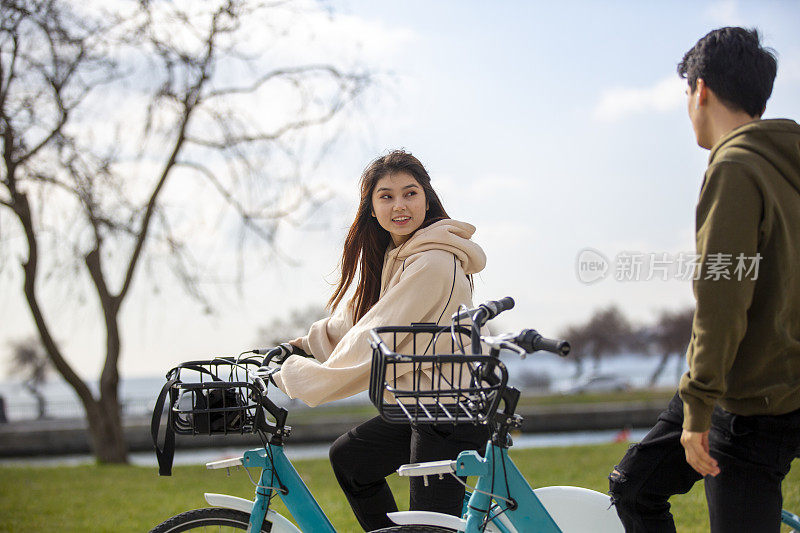 两个亚洲人在公园里骑自行车