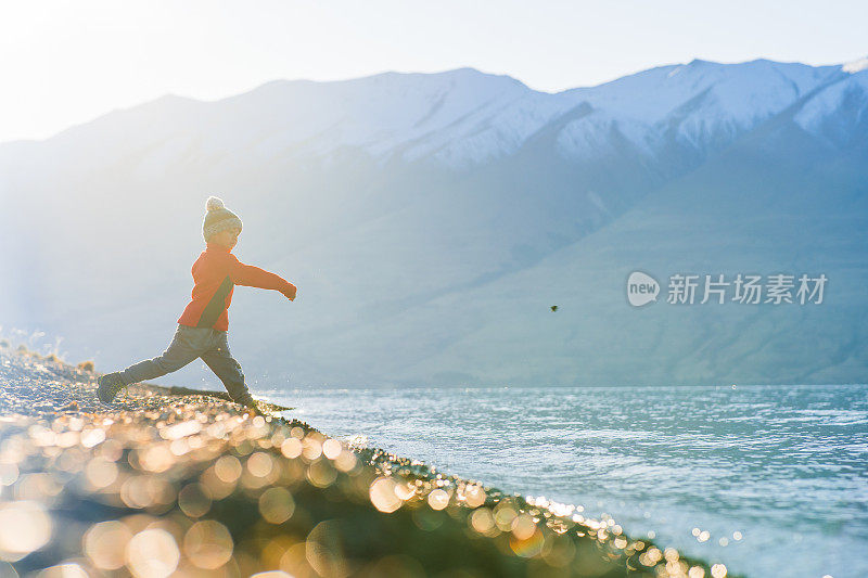 小男孩往湖水里扔石头。