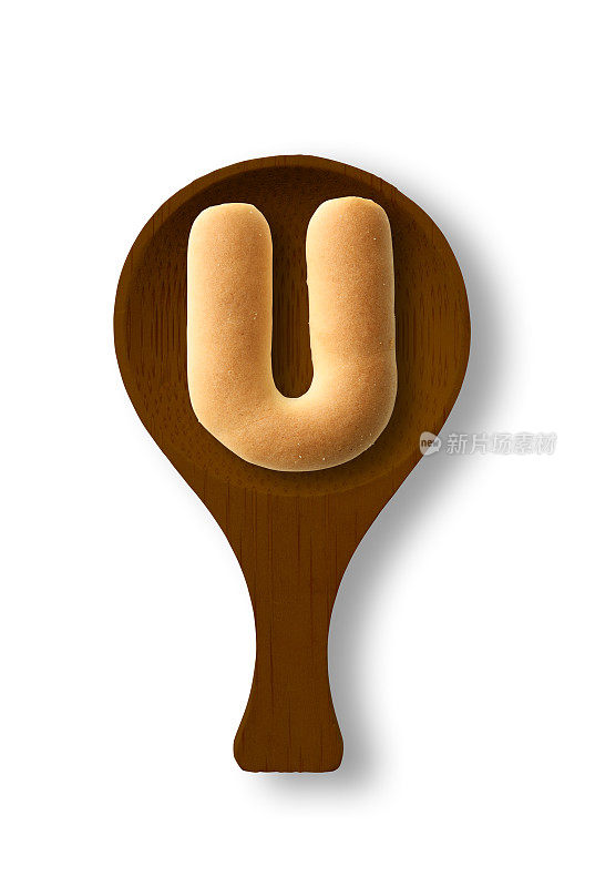 孤立的照片的大写字母饼干U上的木勺，在白色的背景
