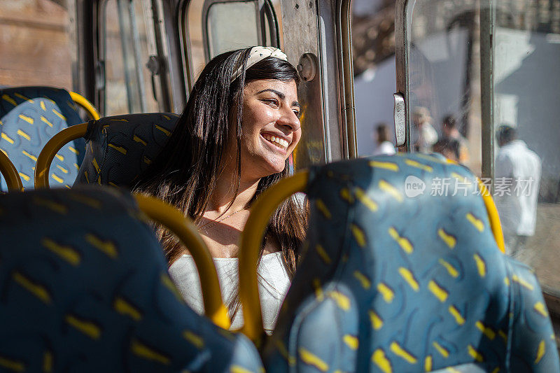 在历史名城的巴士上微笑的女游客。