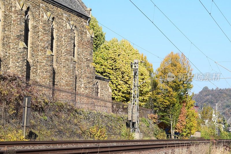 铁路上的石头教堂和秋天的树