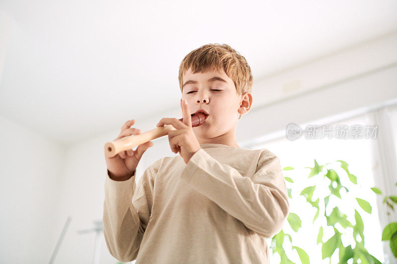 一个在家里练习和学习长笛的孩子的肖像