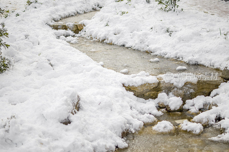 美丽的冬季公园，结冰的水覆盖着雪