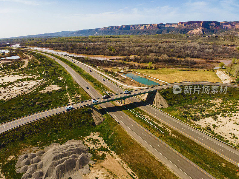 在美国西部70号州际公路和立交桥上驾驶的车辆和卡车的天桥天桥的无人机视图