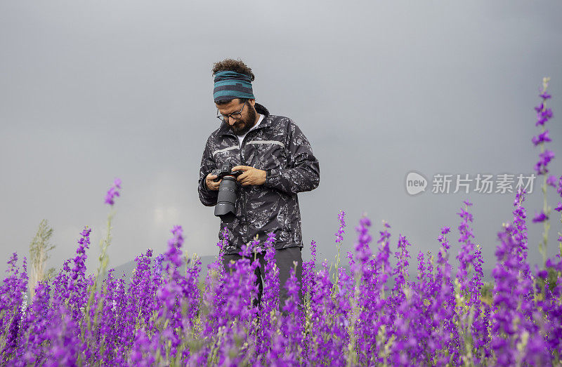 男性摄影师在野外拍摄风景照片