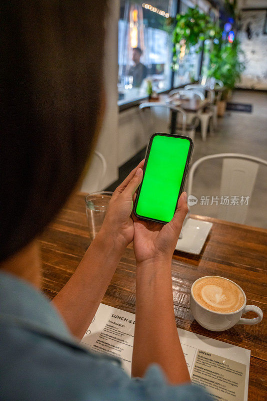 一个女人在咖啡馆里看手机