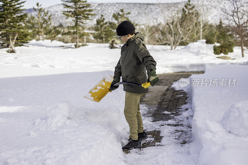 男孩在家里铲雪