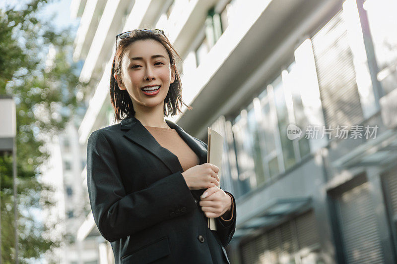 成功的女经理站在城市的大街上。