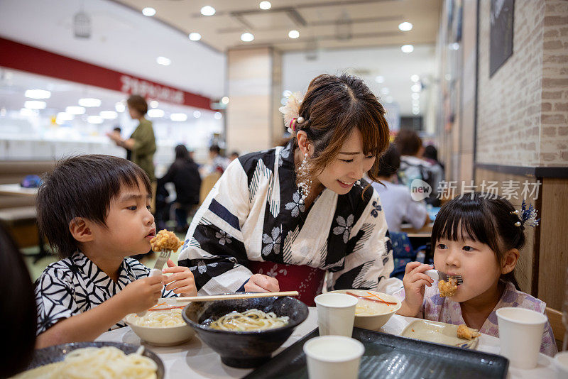 一家人在美食广场吃炸乌冬面