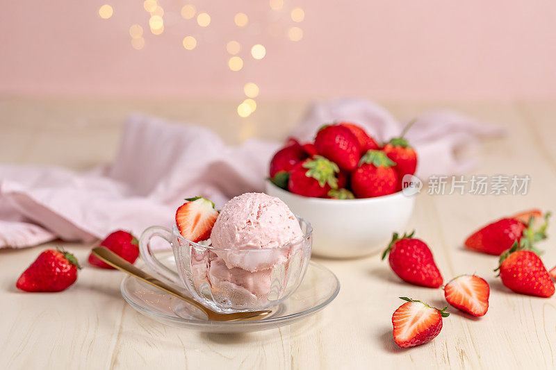 白色木桌上的草莓冰淇淋配上仙女灯