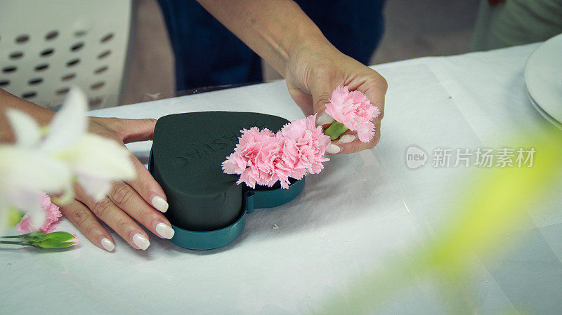 一位美丽的亚洲花艺老师正在为花艺学生示范插花技巧。