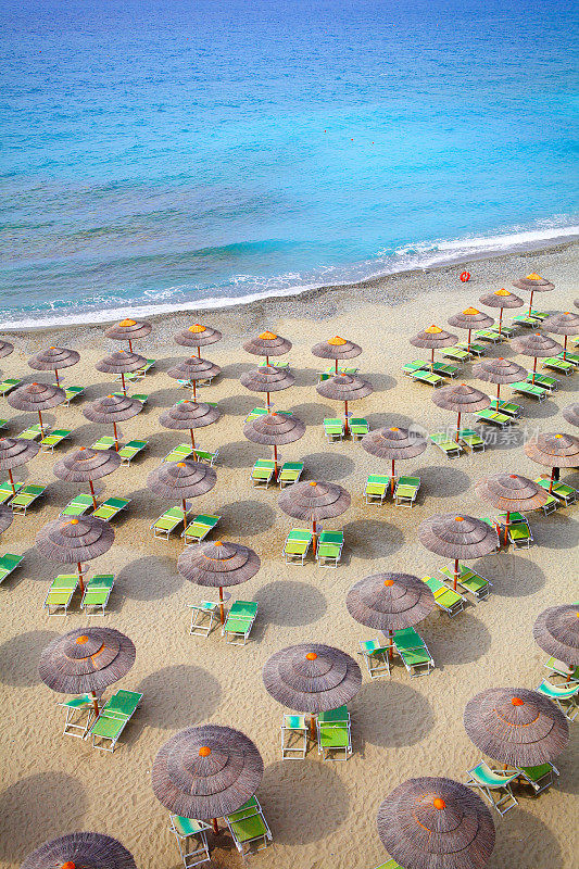 沙滩上的遮阳伞和日光浴床