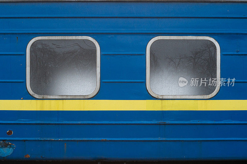下面有黄色条纹的火车蓝色客车的窗户。