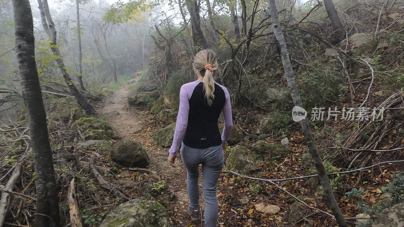 年轻女子在森林中徒步行走