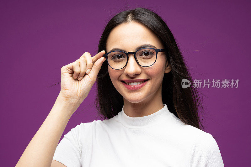 漂亮的年轻女孩的肖像穿着白色t恤孤立的紫色背景股票照片