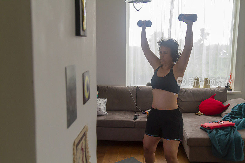 中年成熟妇女做普拉提锻炼的指导下，从私人教练在家里通过电视