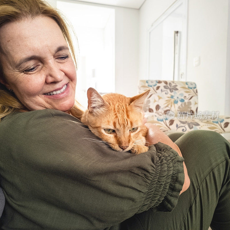 女人和他的姜黄色猫在家里。