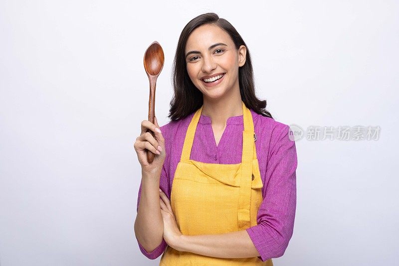 年轻女厨师的肖像穿着黄色围裙孤立白色背景股票照片