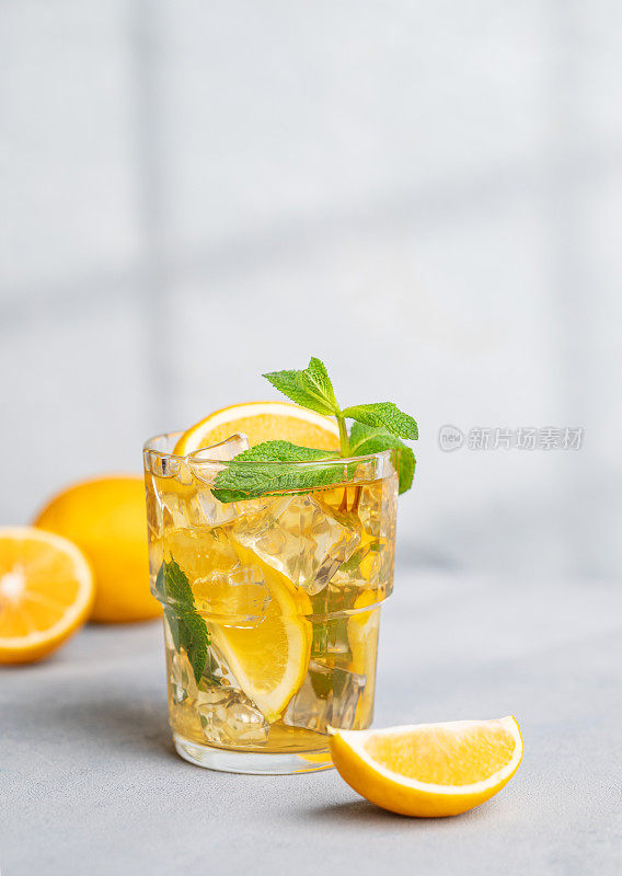 冰茶加柠檬，薄荷，在浅色背景，阴影和柑橘水果。