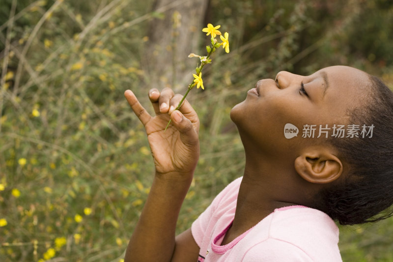 年轻的黑人女孩吹着黄色的羽毛