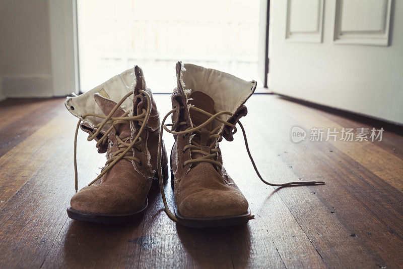 一双男人的旧皮靴在家门口