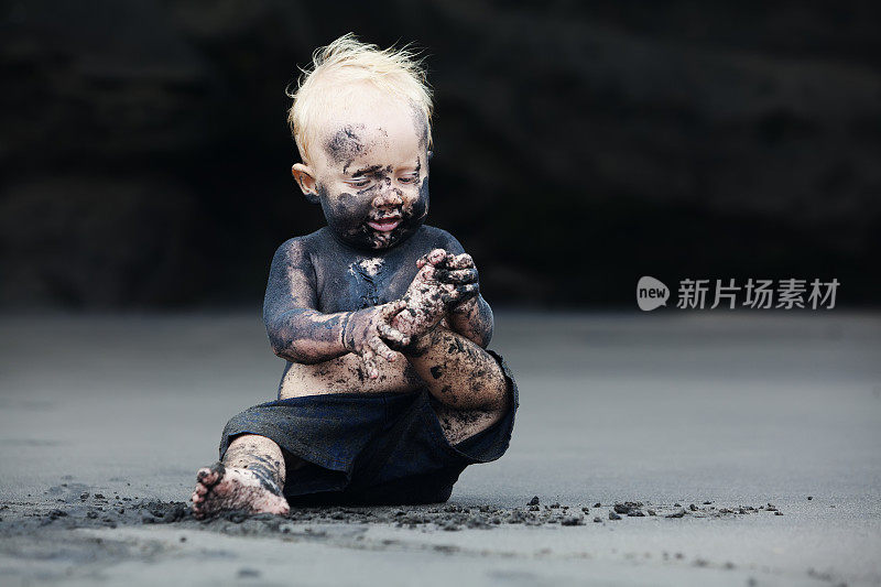 黑沙滩上脏兮兮的孩子的肖像