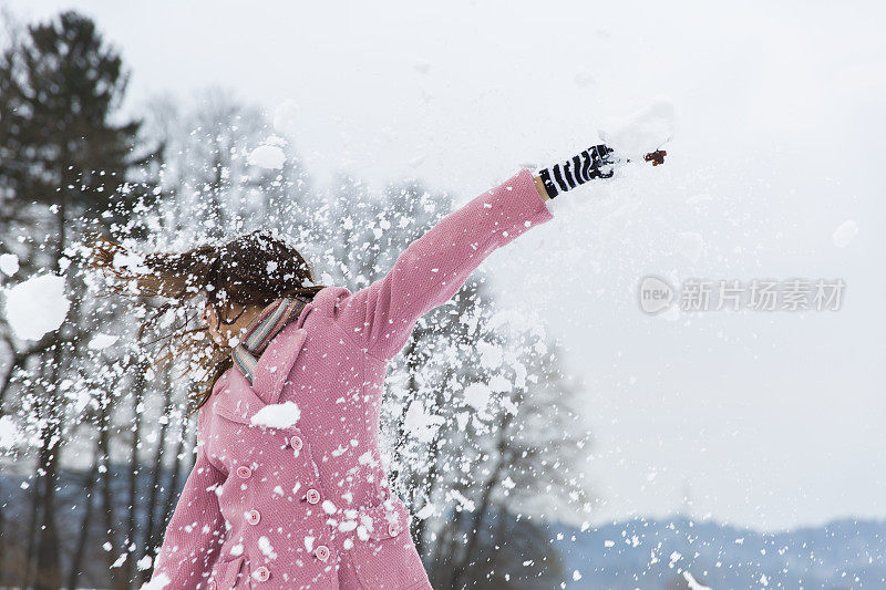 可爱的年轻女子被雪球砸中了