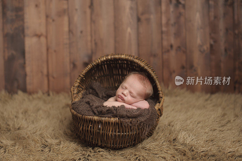新生儿睡在柳条篮子里