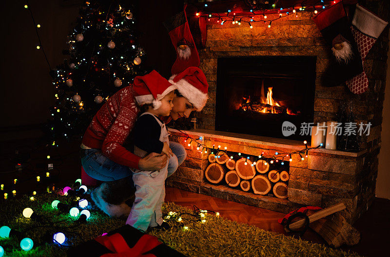 母亲和儿子在圣诞夜的壁炉旁