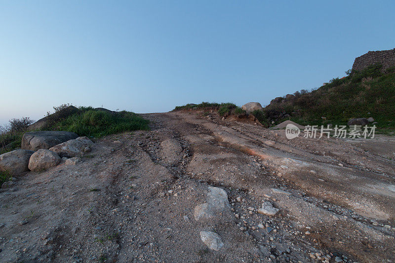 岩石路在黄昏与轮胎印汽车商业