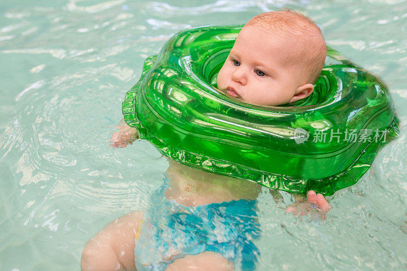婴儿在充气圈的帮助下游泳。