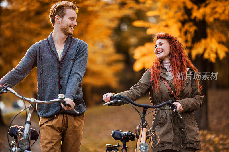 年轻幸福的夫妇与自行车在大自然中交流。